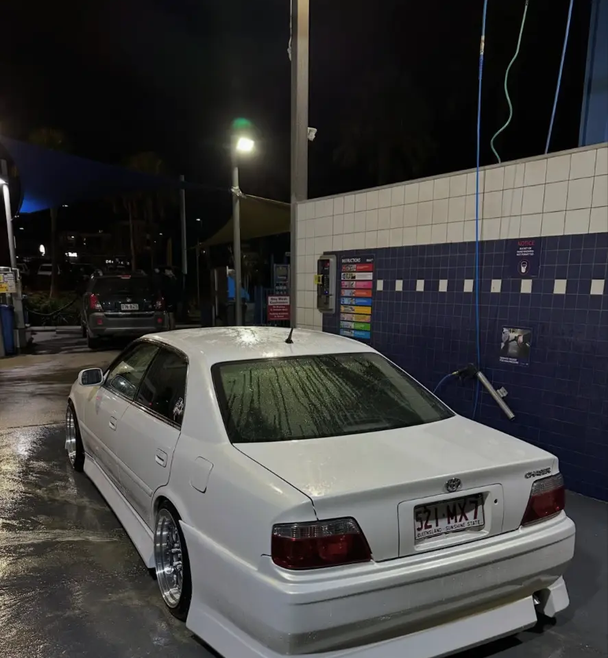 White Toyota Chaser JZX100 with freshly painted body kit at a night car wash